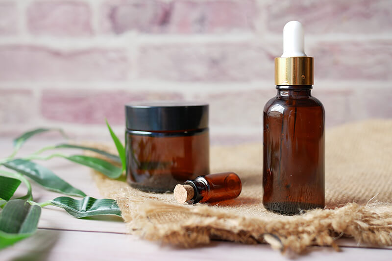Na stole leżą zaciemnione buteleczki naturalnego ekstraktu z buzdyganka ziemnego.