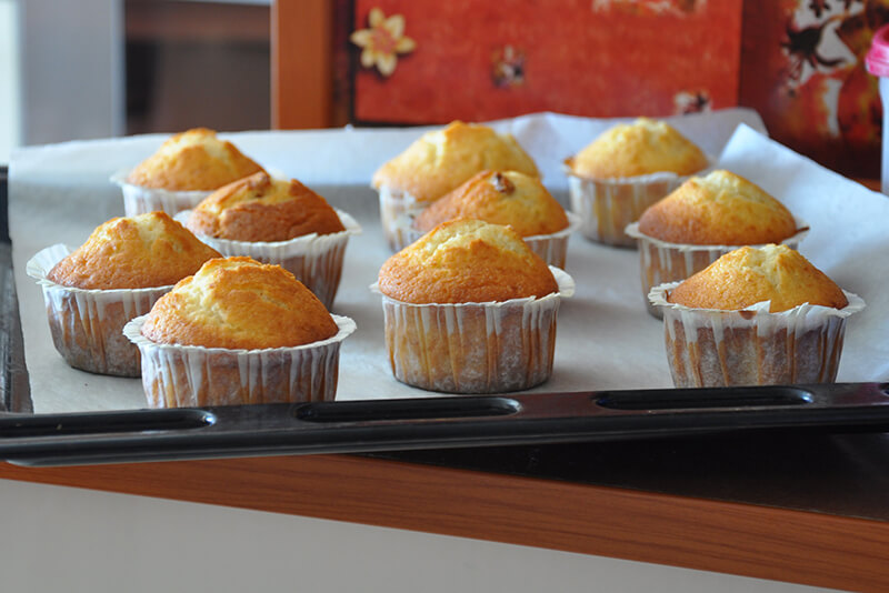 Na blaszce studzą się świeżo upieczone babeczki z dodatkiem ekstraktu waniliowego.