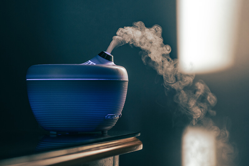 Na stole pracuje dyfuzor wypełniony eterycznymi olejkami do inhalacji.
