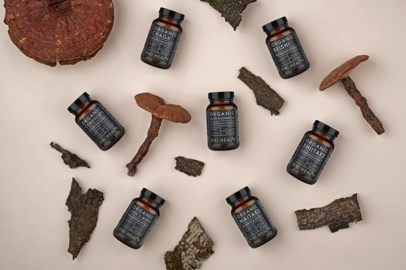 Na stole leżą same naturalne produkty – kora, grzyby oraz organiczne suplementy zawierające ekstrakty z grzybków shiitake.
